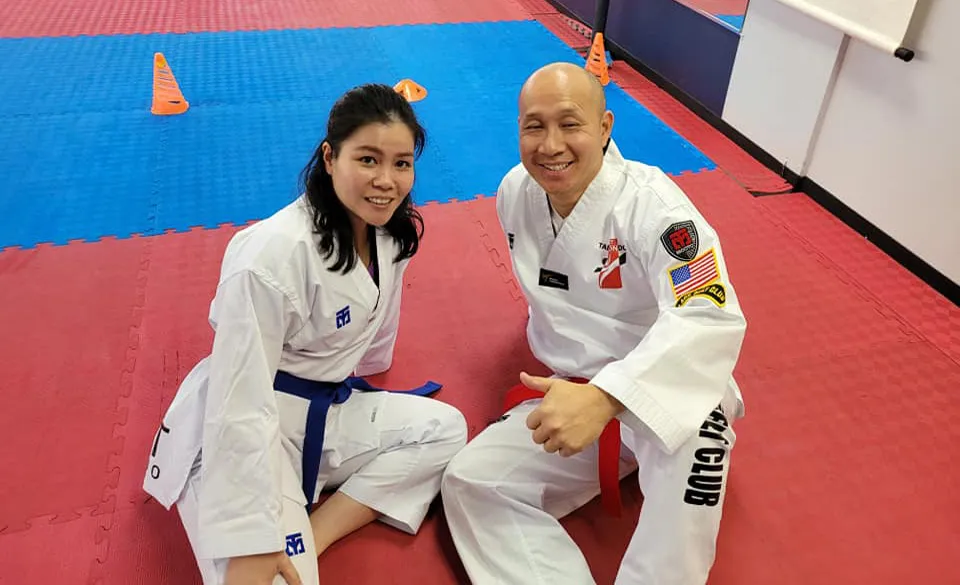two-taekwondo-practitioners-smiling-on-mat