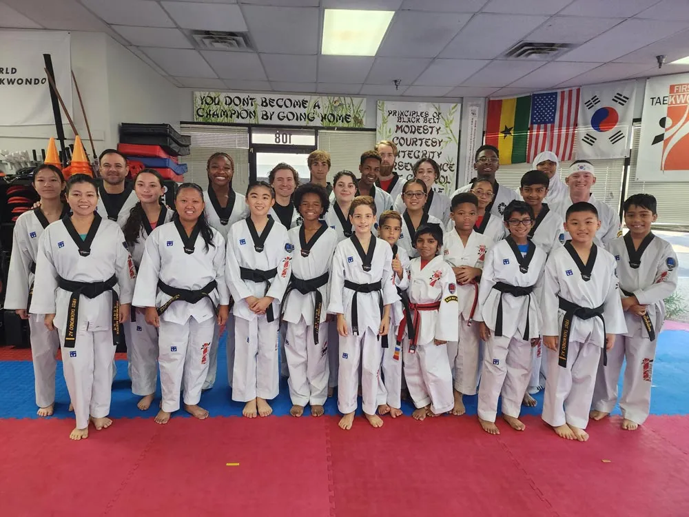 diverse-group-of-taekwondo-students-and-instructors-smiling-together-in-dojo